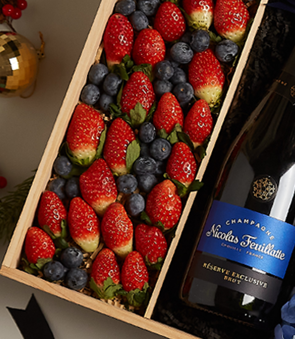 Elegant holiday gift tray with strawberries, blueberries, and festive floral decor for special celebrations.