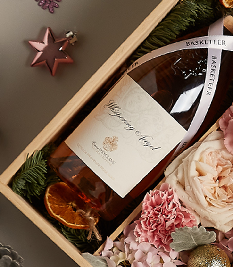 Luxury floral gift box with pastel blooms, golden accents, and festive decorations for the holiday season.