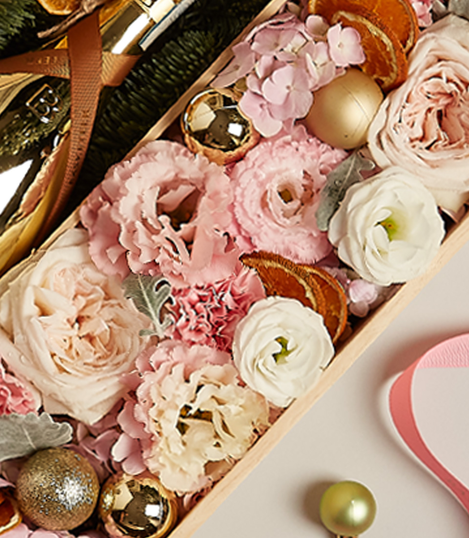 Blush and gold-themed gift hamper featuring Bottega Gold Prosecco, pastel floral arrangements, and festive decorations.