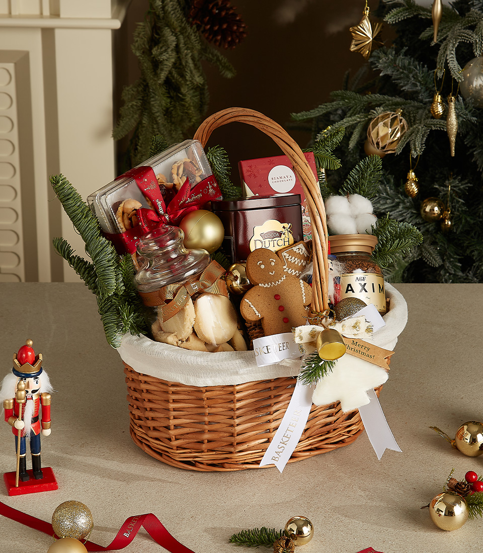 Elegant wicker basket with gourmet Dutch cookies, chocolates, gingerbread, and festive holiday decorations, including a nutcracker.