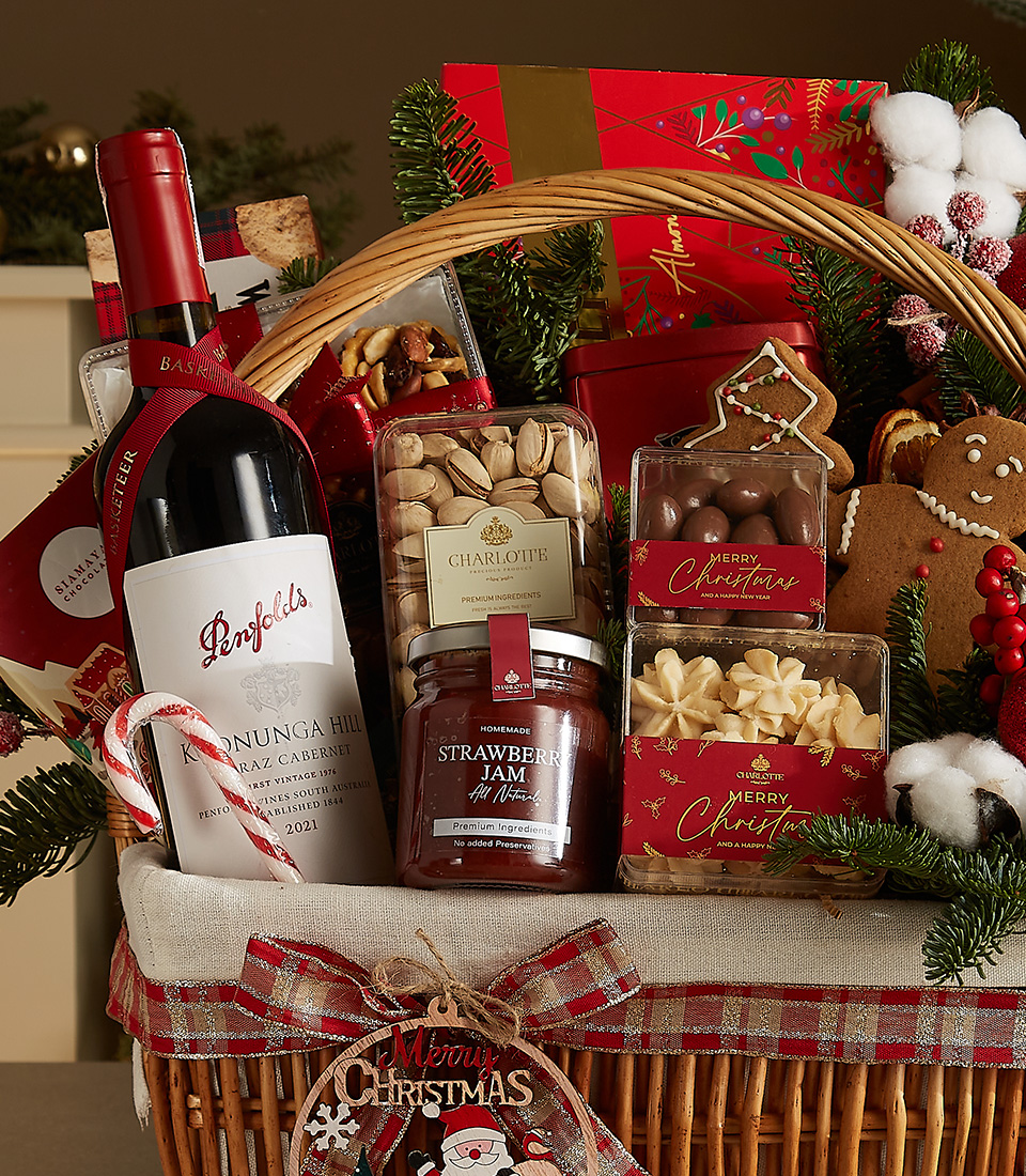 Festive wicker basket with Penfolds wine, Walkers shortbread, strawberry jam, gingerbread cookie, and holiday-themed gourmet treats.