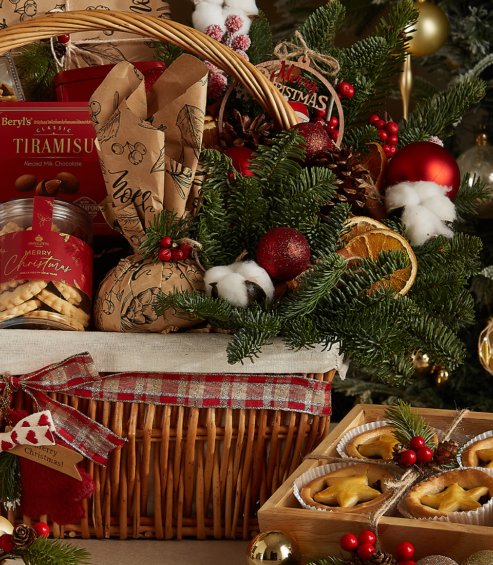Luxurious holiday wicker hamper with premium wine, plum pudding, fruit mince pies, tiramisu biscuits, cookies, and festive ornaments.