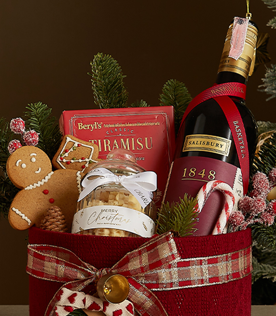 Red velvet gift box featuring 1848 wine, Tiramisu chocolates, a gingerbread cookie, and holiday-inspired cookies with festive decorations.
