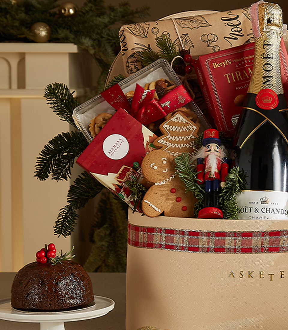 Luxurious Christmas gift basket with Moët & Chandon, gourmet treats, holiday pastries, and festive decorations.