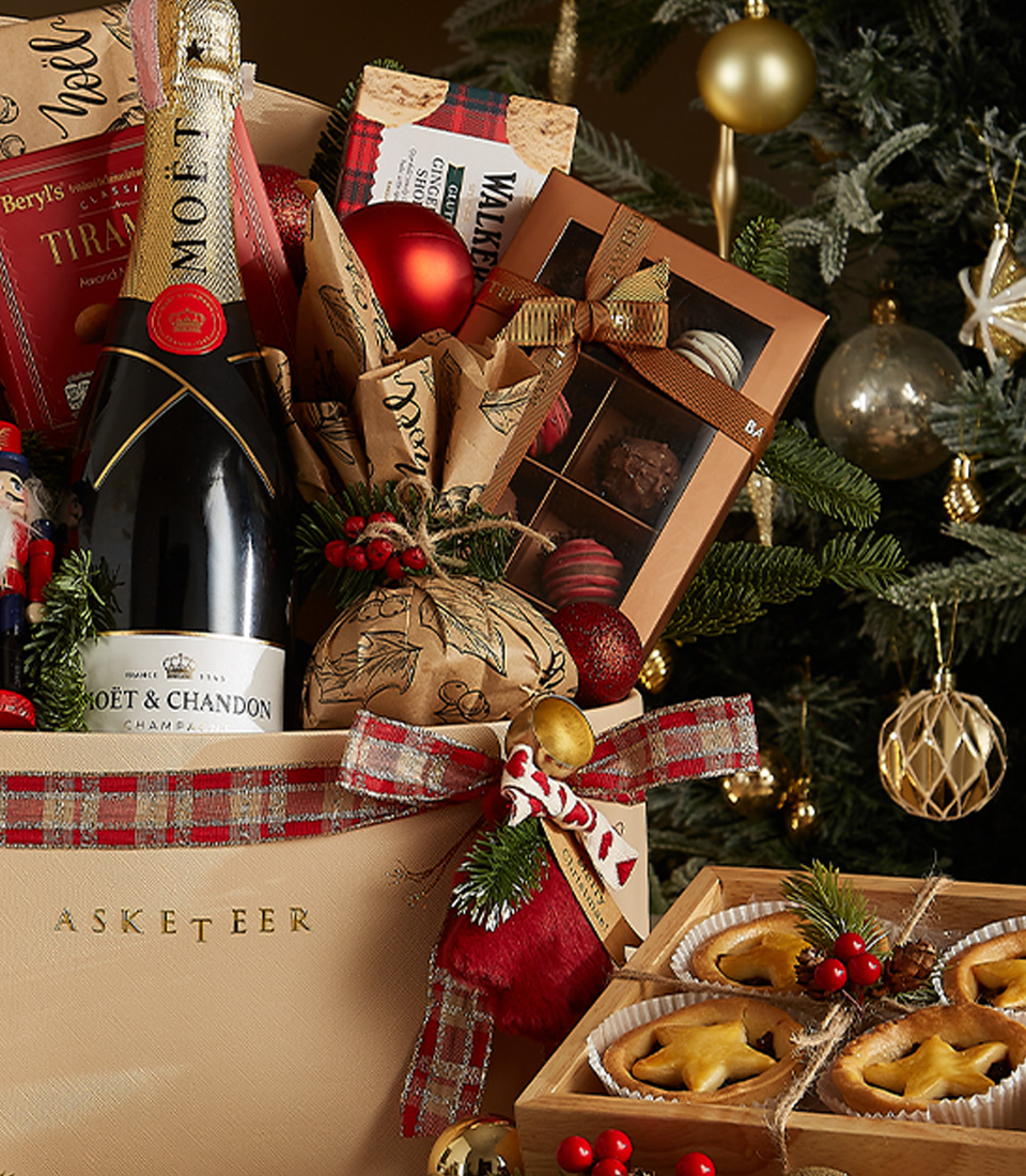 Luxurious Christmas gift basket with Moët & Chandon, gourmet treats, holiday pastries, and festive decorations.