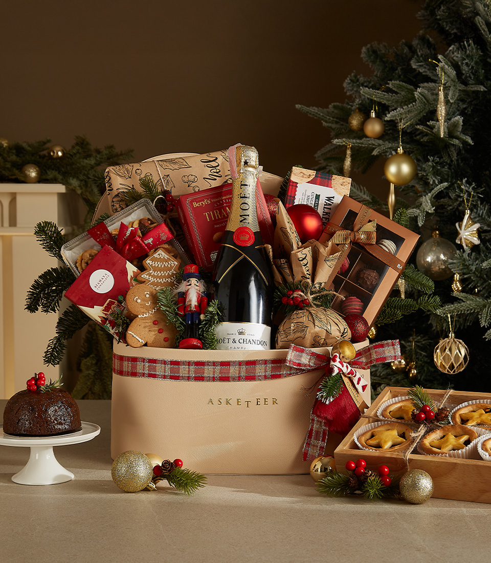 Luxurious Christmas gift basket with Moët & Chandon, gourmet treats, holiday pastries, and festive decorations.