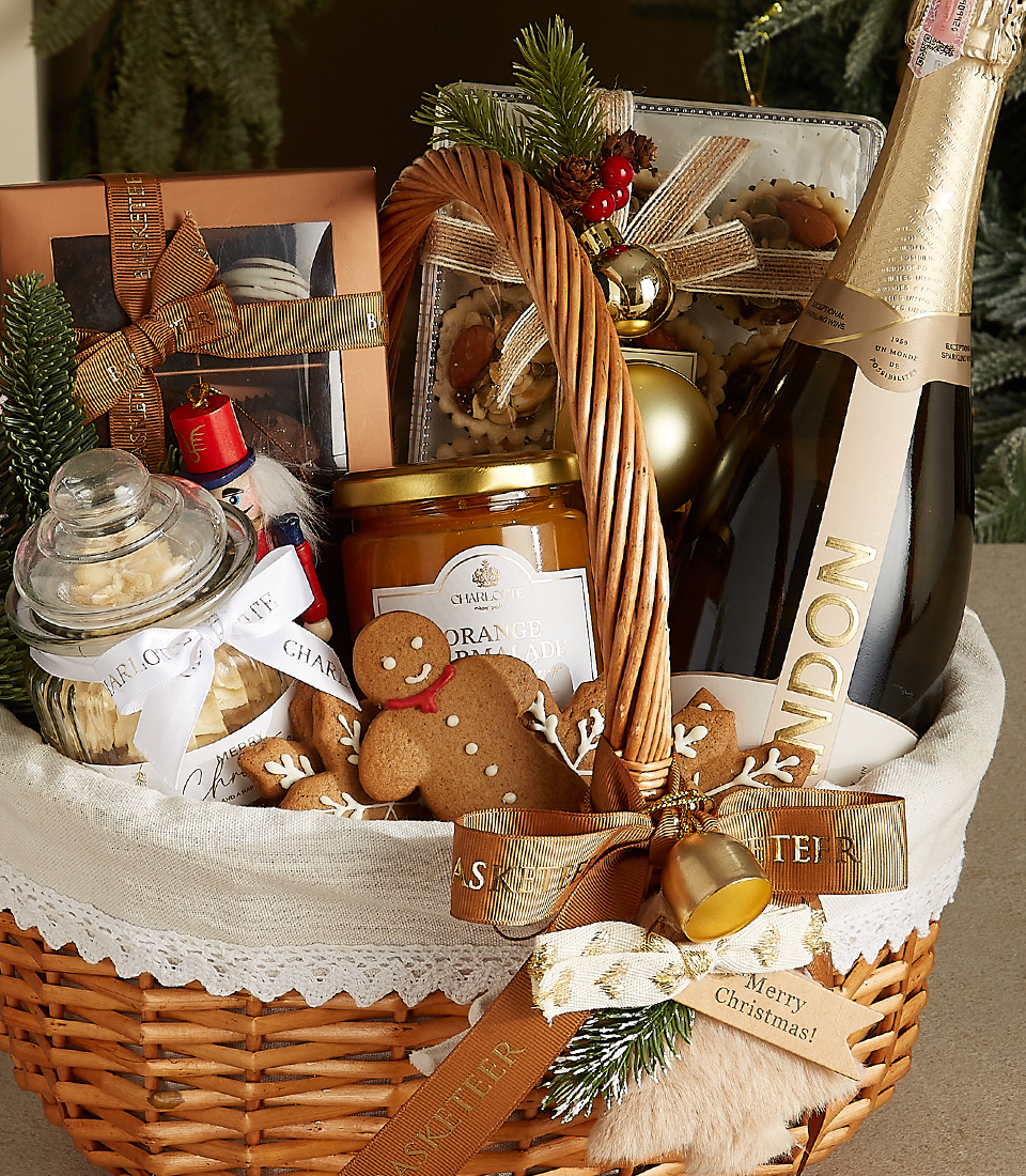 Wicker basket with Chandon champagne, gingerbread cookies, honey jar, shortbread cookies, and festive decorations.