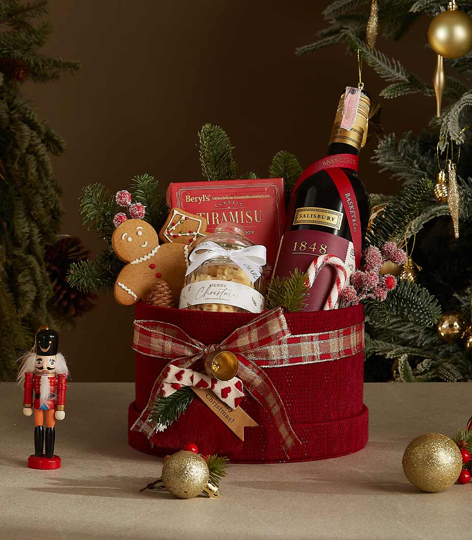 Red velvet gift box featuring 1848 wine, Tiramisu chocolates, a gingerbread cookie, and holiday-inspired cookies with festive decorations.