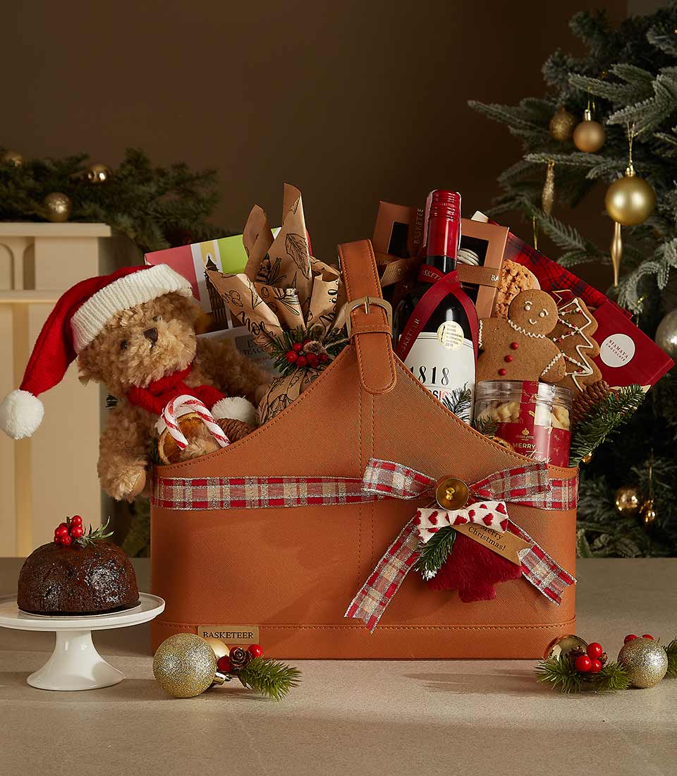 Luxurious leather Christmas gift basket featuring 1818 Classic wine, gourmet snacks, festive cookies, a plush Santa bear, and holiday decor.