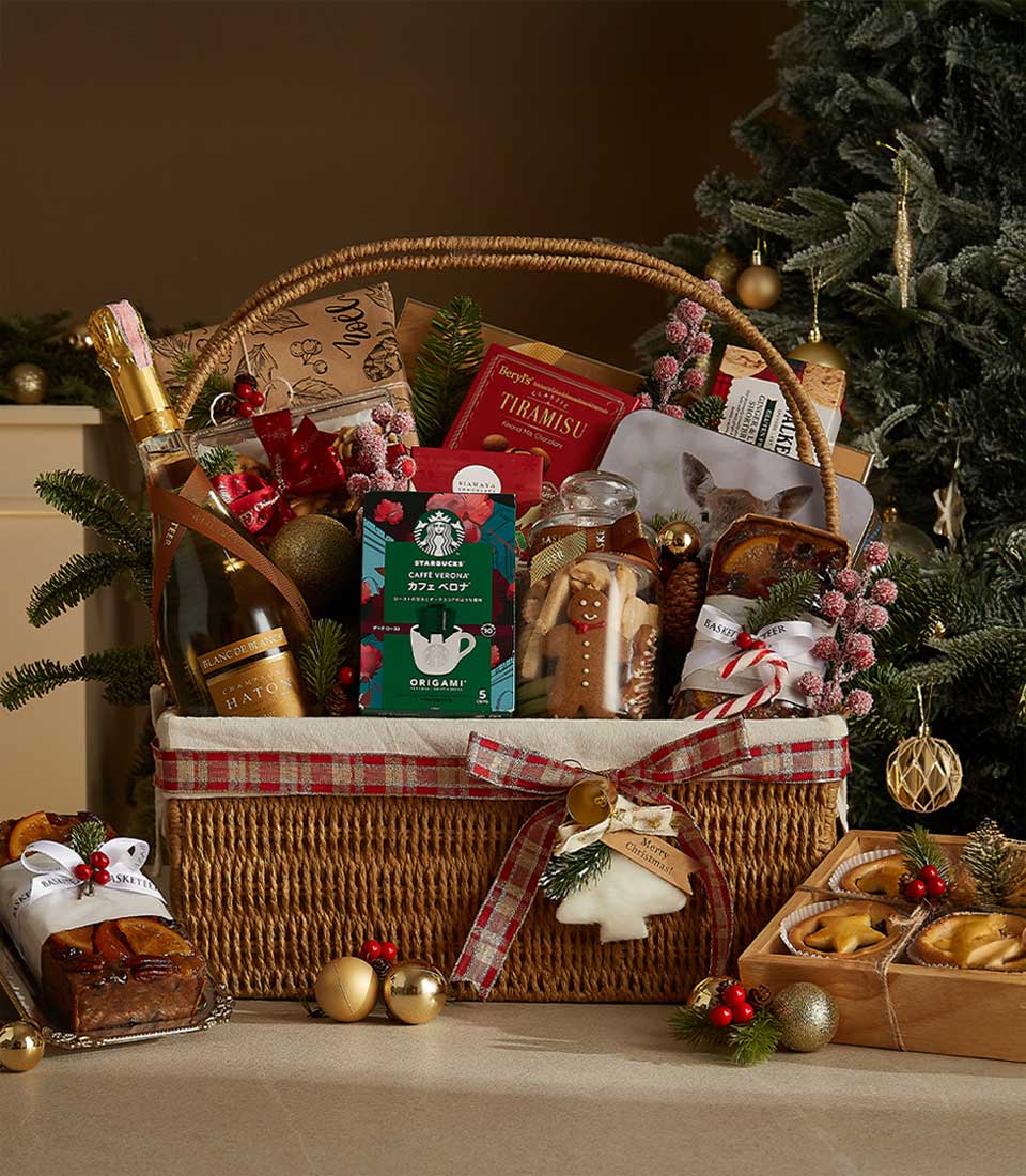 Festive holiday gift basket with Bottega Gold sparkling wine, Starbucks coffee, mince pies, fruitcake, cookies, and festive decorations.