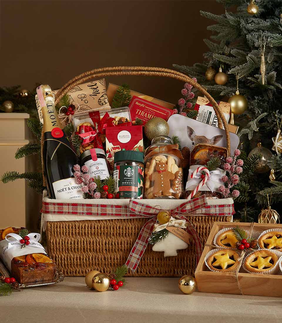 Luxury holiday gift hamper featuring Moët & Chandon champagne, Starbucks coffee, gingerbread cookies, mince pies, fruitcake, and festive decor.