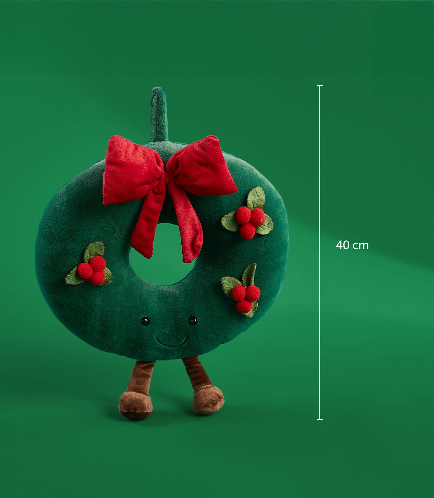 40 cm plush Christmas wreath with a red bow, holly decorations, and a smiling face on a green background.