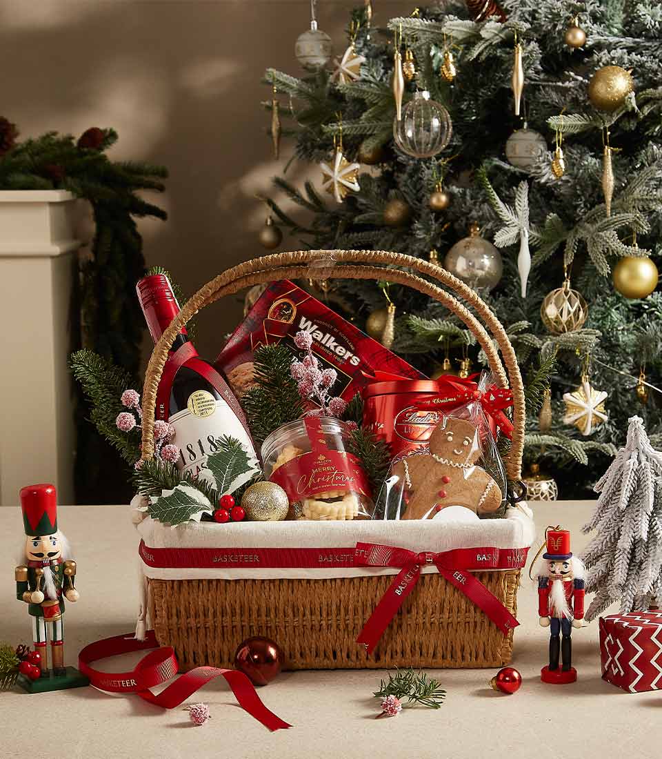 Holiday gift basket with teddy bear, fruitcake, cookies, and festive treats, perfect for Christmas celebrations.