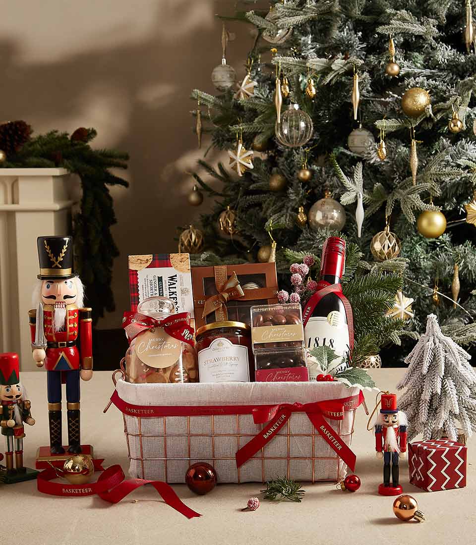 Classic holiday gift basket with cookies, jam, tea, and festive decorations, ideal for seasonal gifting.