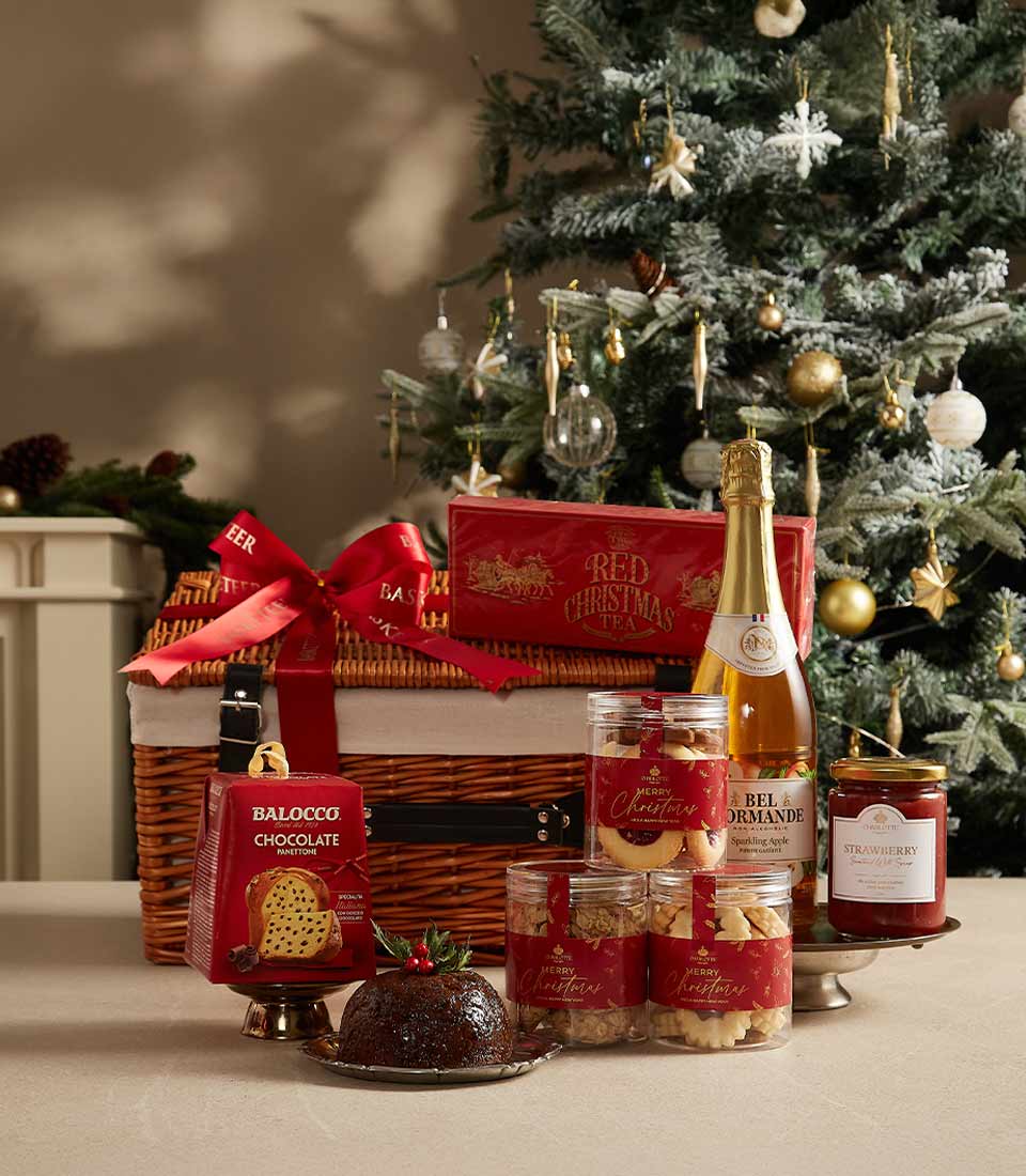 Holiday gift hamper with festive treats, premium tea, cookies, and gourmet jam, beautifully arranged for celebrations.