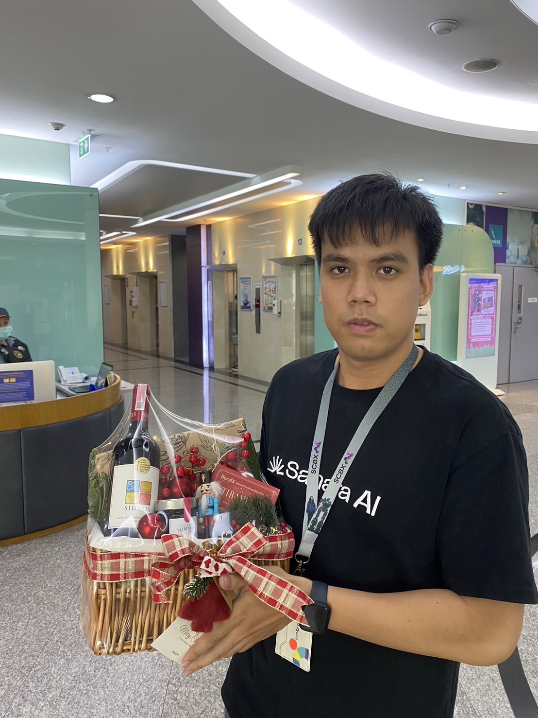 A holiday gift basket with Signus wine, gourmet treats, and festive decorations, wrapped with a red plaid ribbon and holiday tag.