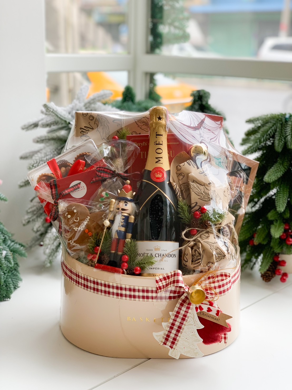 Luxurious Christmas gift basket with Moët & Chandon, gourmet treats, holiday pastries, and festive decorations.