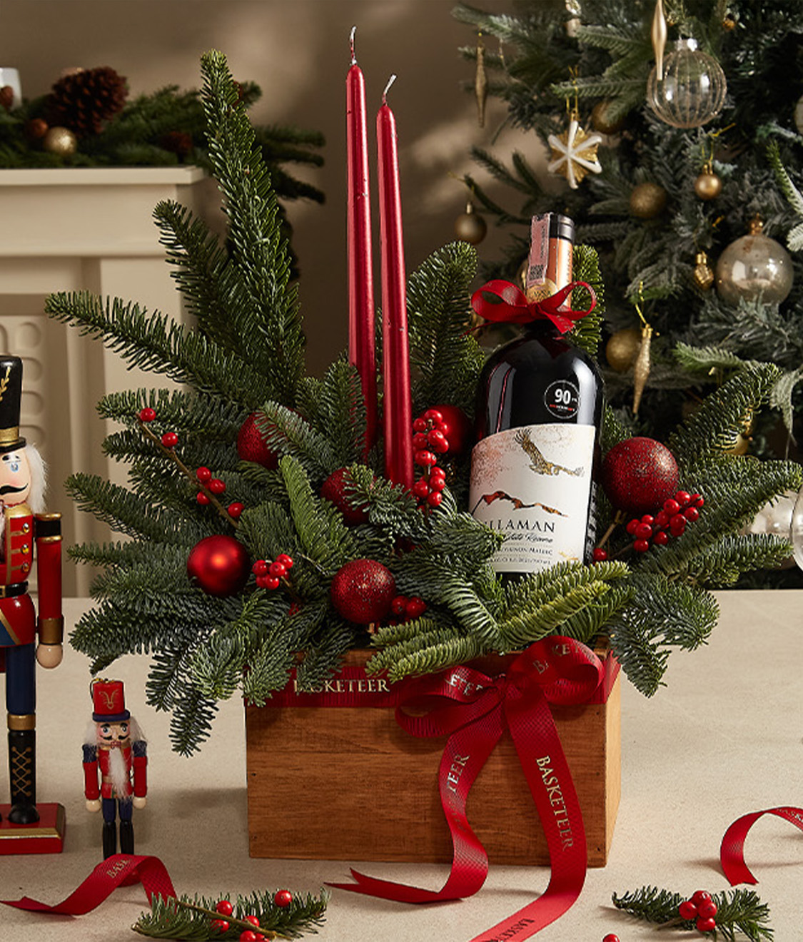 Elegant holiday centerpiece featuring a bottle of Millaman wine, red candles, festive greenery, ornaments, and ribbon accents for Christmas decor.