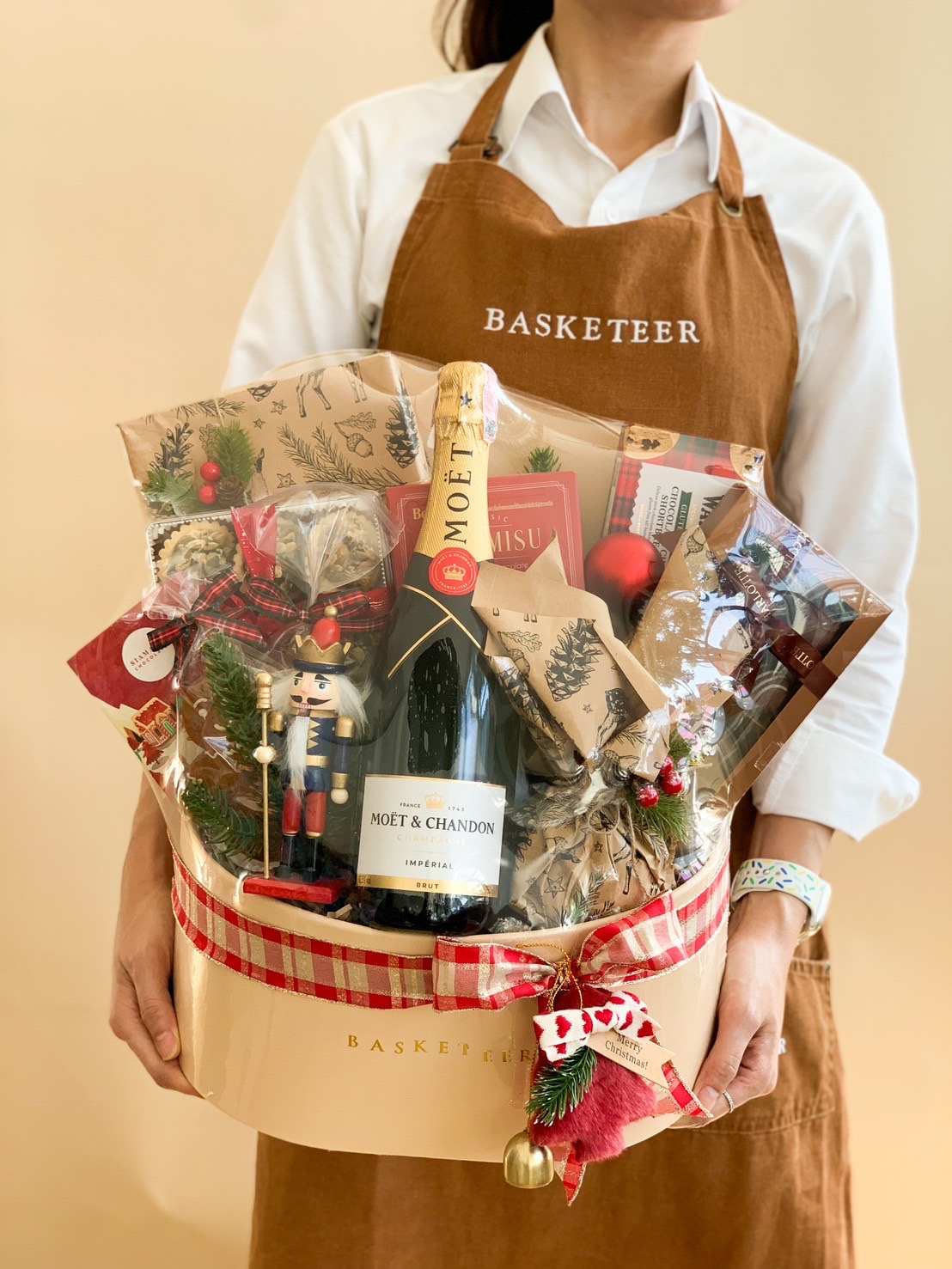 Luxurious Christmas gift basket with Moët & Chandon, gourmet treats, holiday pastries, and festive decorations.