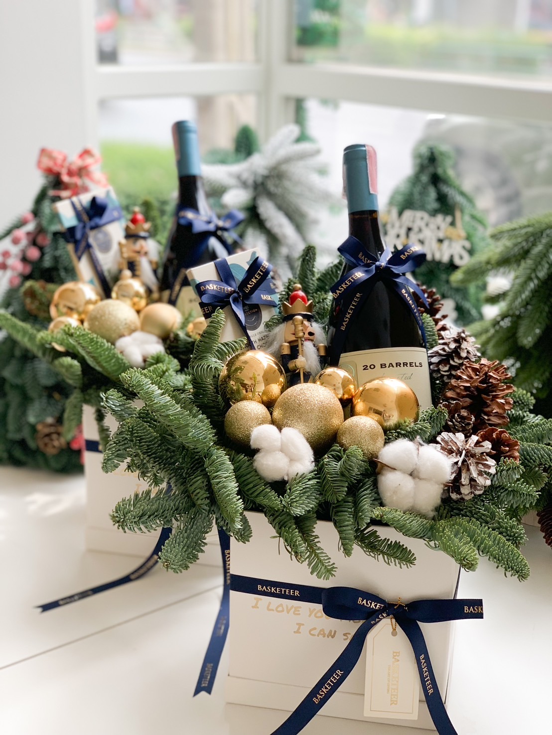 Christmas gift box with pine greenery, ornaments, and premium holiday treats, ideal for festive gifting.