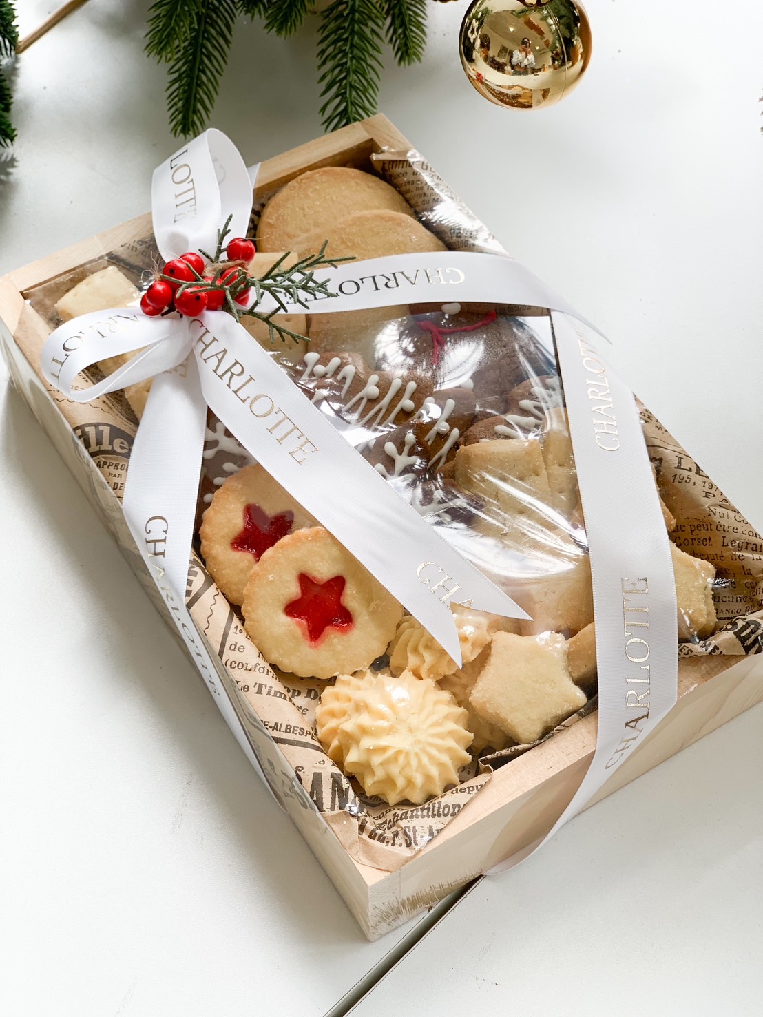A wooden Charlotte Bakery gift box in Bangkok filled with buttery star and jam heart biscuits, tied with a white ribbon and festive decor.