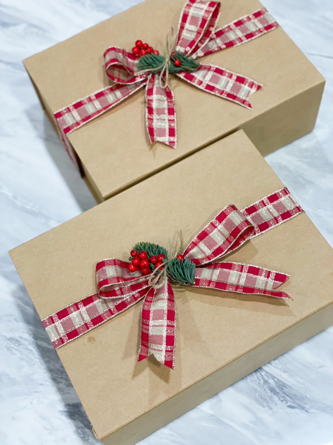 A festive Christmas gift box featuring a nutcracker, tiramisu almonds, butter cookies, a "Merry Christmas" mug, marshmallows, candy canes, and a gingerbread cookie, beautifully arranged with pine greenery, red berries, and holiday decorations, perfect for celebrating the holiday season.