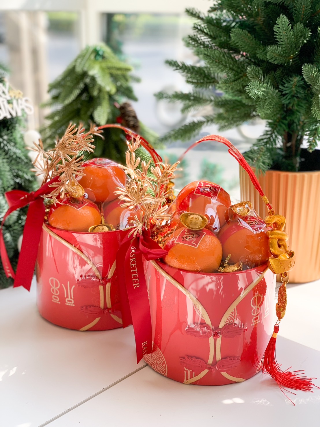Luxurious red barrel gift set containing fresh mandarins, adorned with gold accents, red ribbons, and festive decorations for Chinese New Year.
