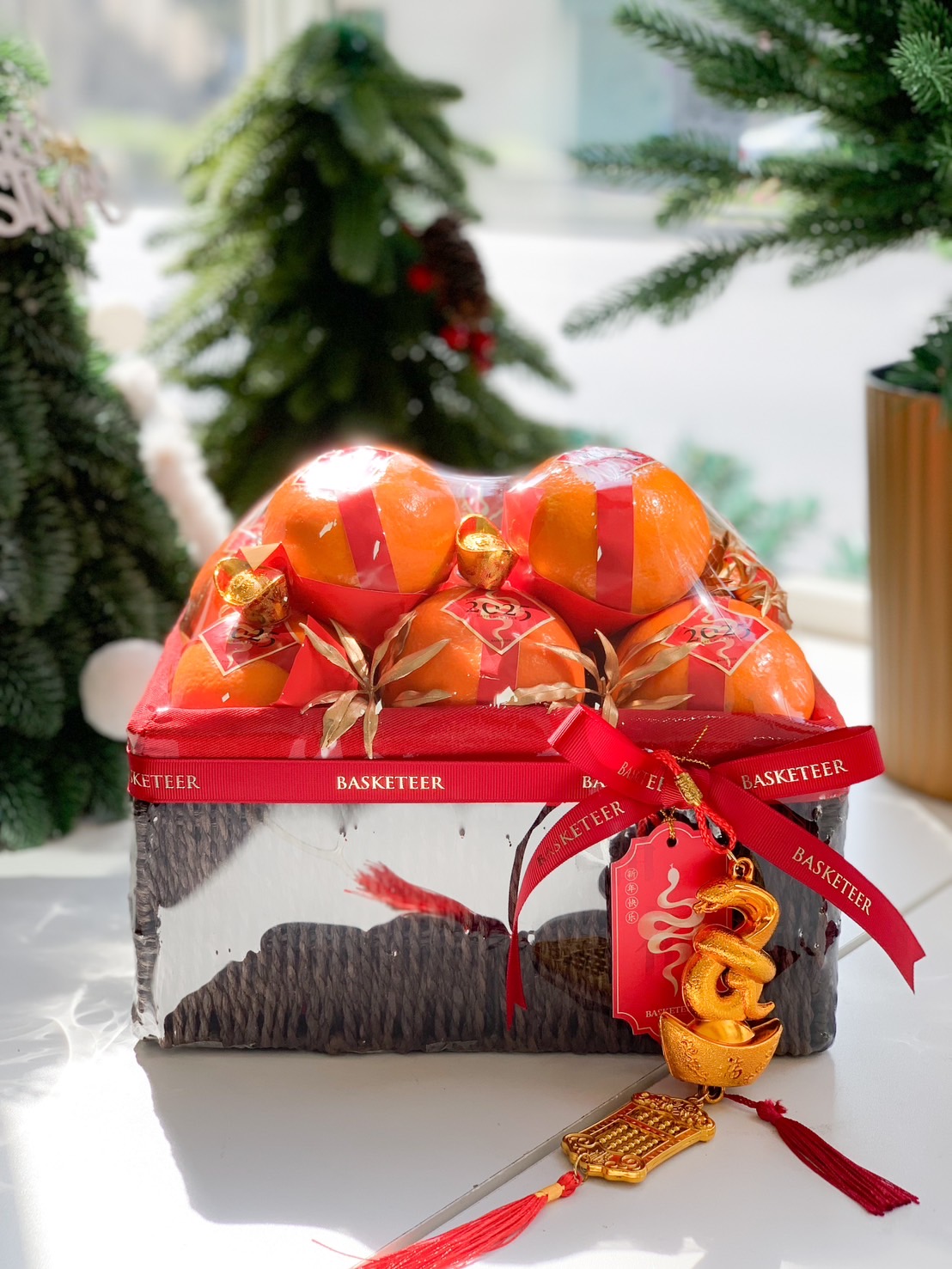 Chinese New Year festive orange basket with premium oranges and red and gold decorations.