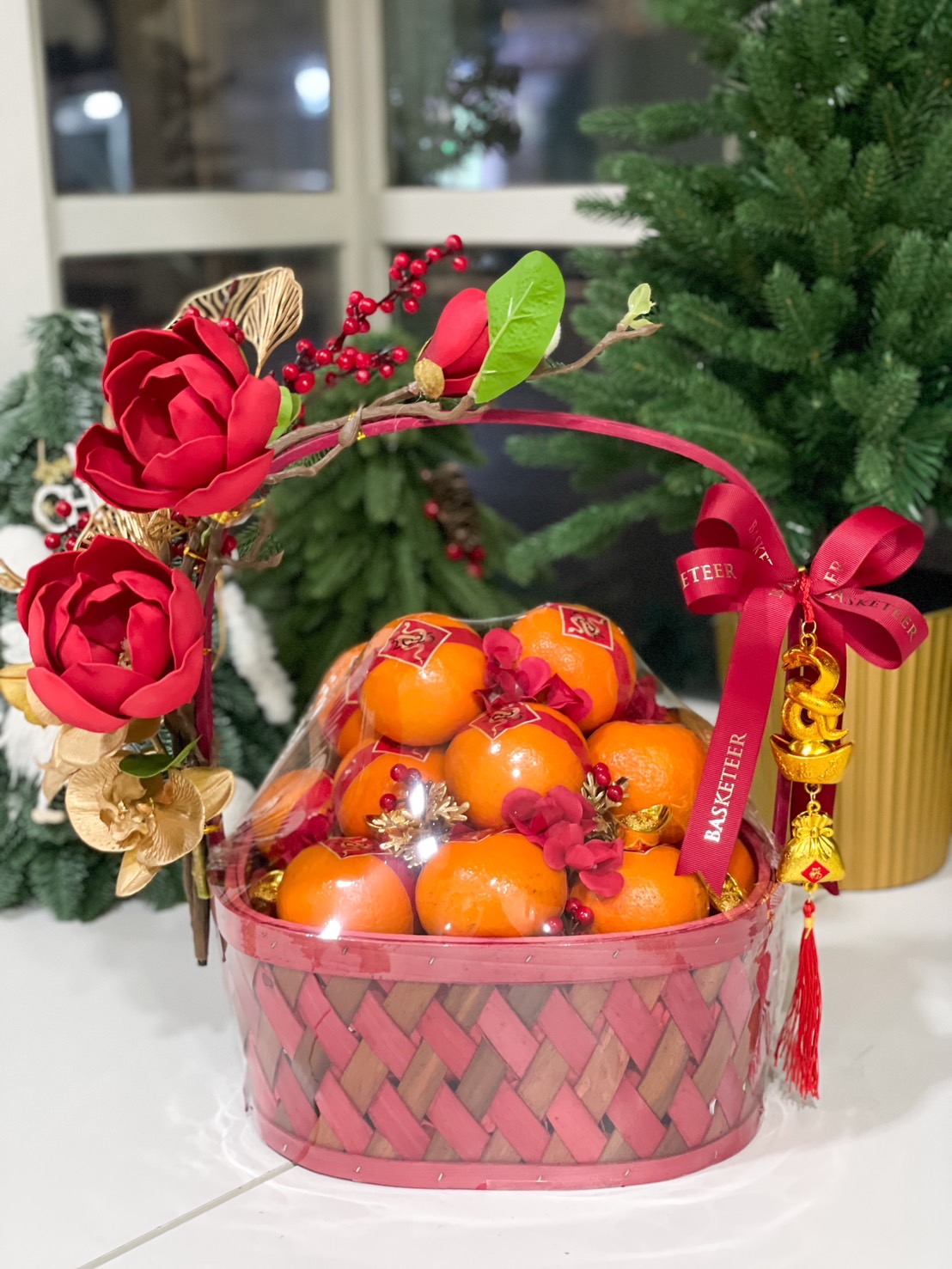Luxurious orange gift basket with premium oranges, red flowers, and golden accents for Chinese New Year.