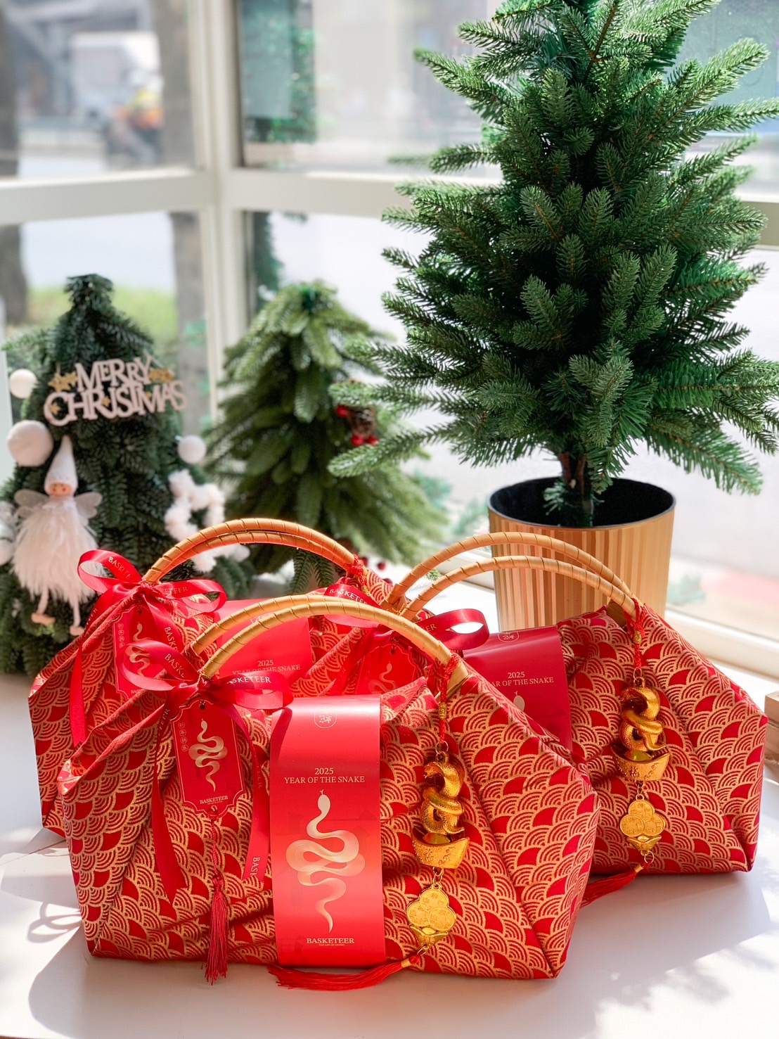 Festive red fabric gift baskets with gold wave patterns, bamboo handles, and snake-themed charms for Chinese New Year celebrations.