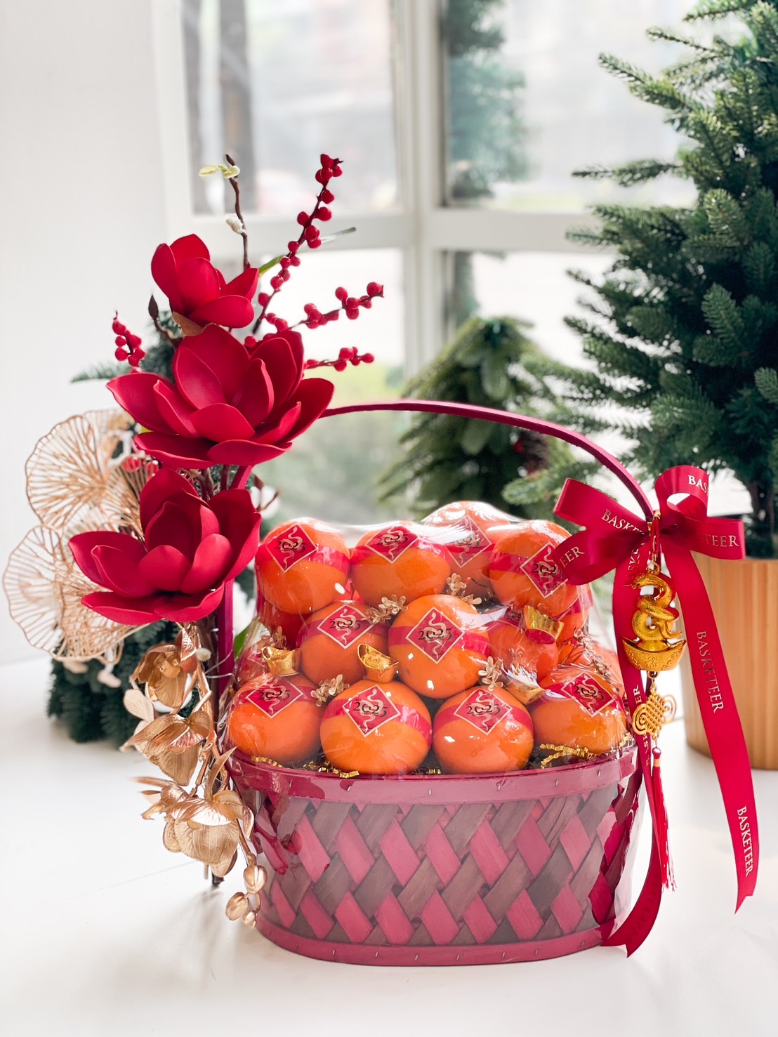 Luxurious orange gift basket with premium oranges, red flowers, and golden accents for Chinese New Year.