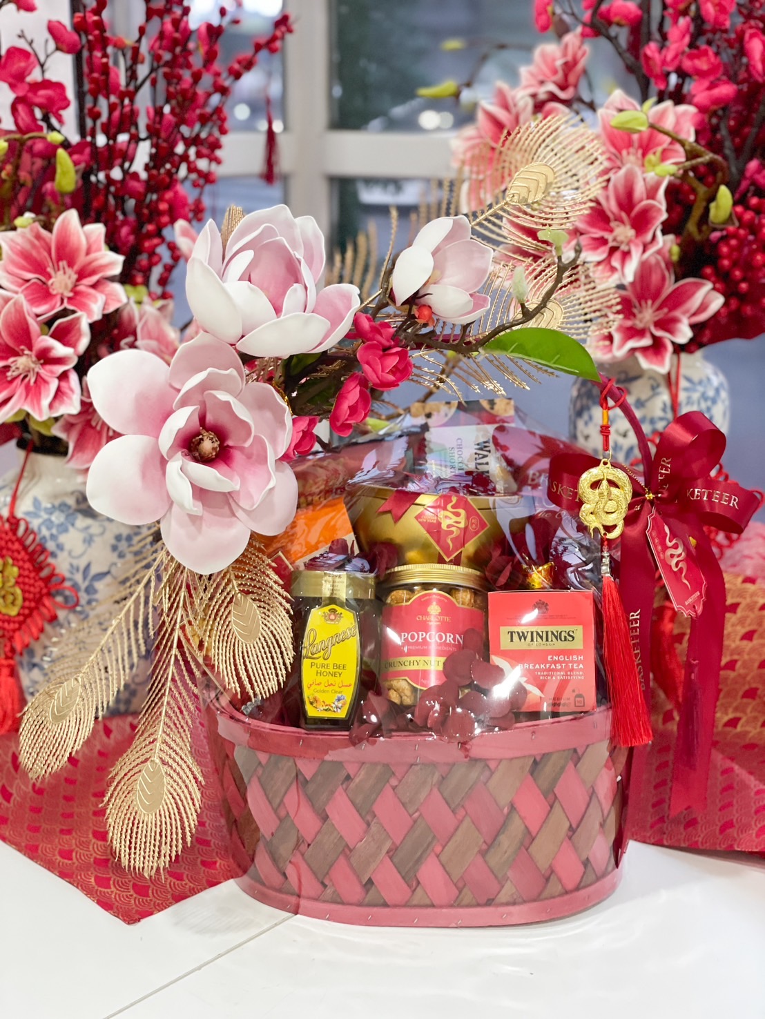 Premium red Chinese New Year celebration basket with oranges, Twinings tea, and gourmet treats.