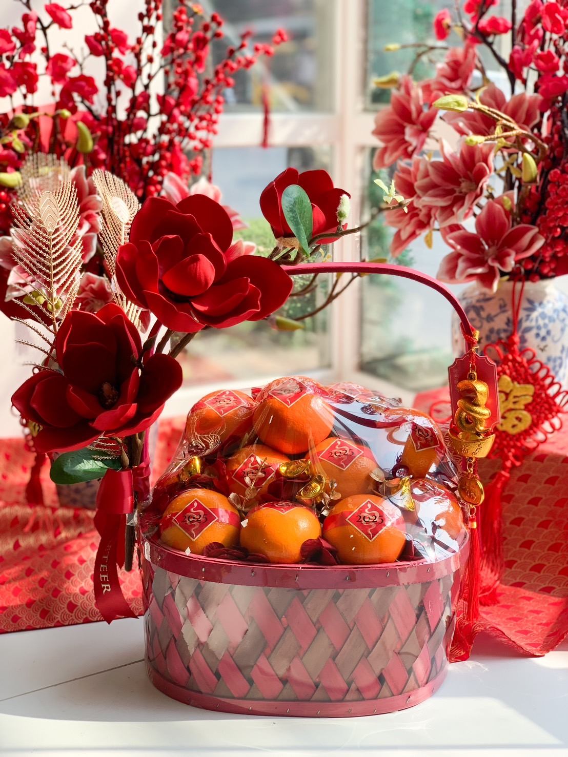 Elegant red Chinese New Year prosperity basket with premium oranges and decorative red accents.