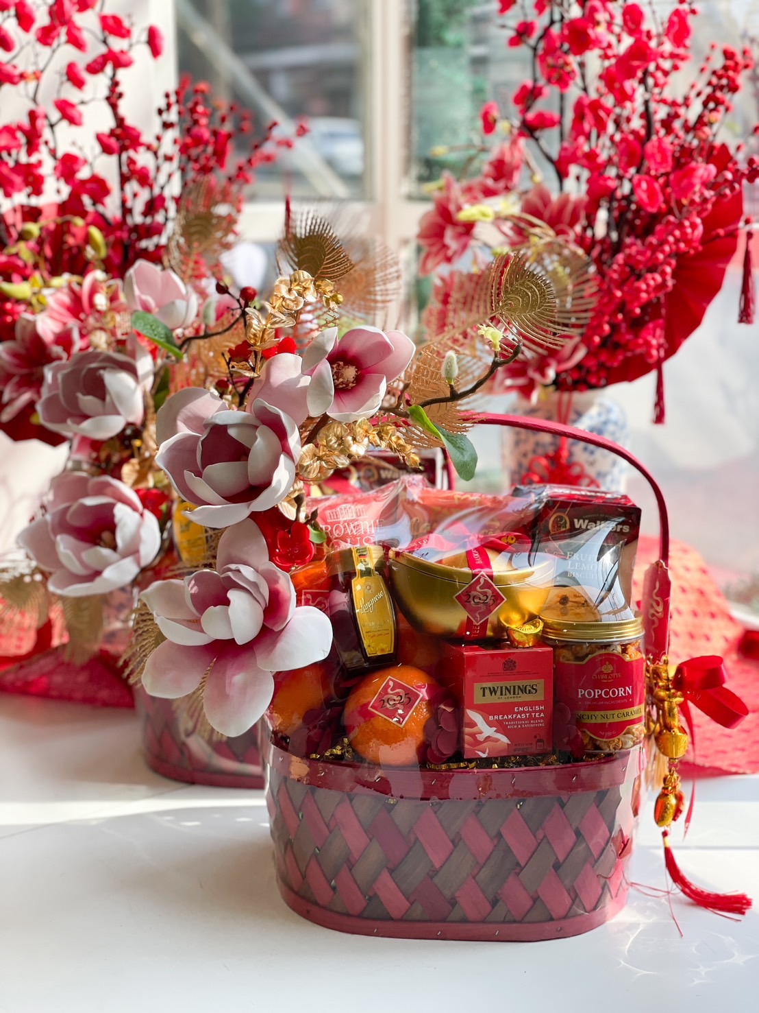Luxury Chinese New Year gift basket with Mandarin oranges, gourmet treats, floral decorations, and gold accents for prosperity and celebration.
