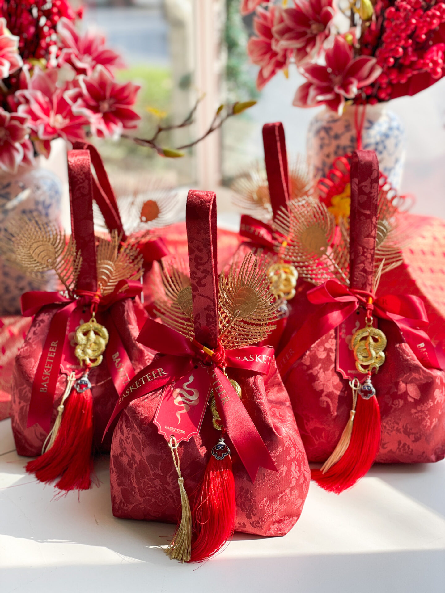 Chinese New Year fortune gift bag wrapped in red fabric with gold accents, festive ribbons, and traditional good luck charms.