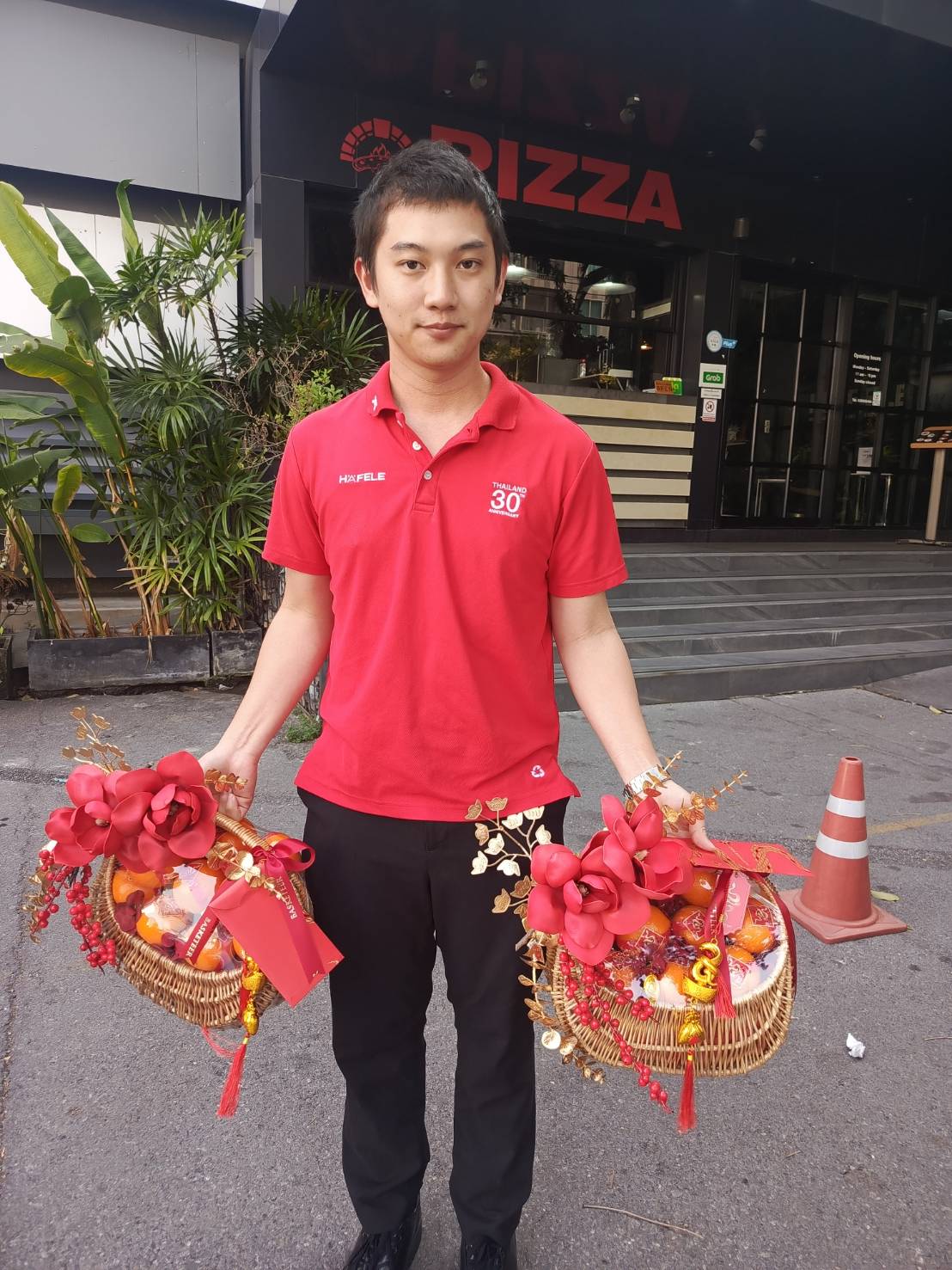 Mini Chinese New Year gift baskets with mandarin oranges, festive treats, red floral decorations, and gold accents for good fortune.