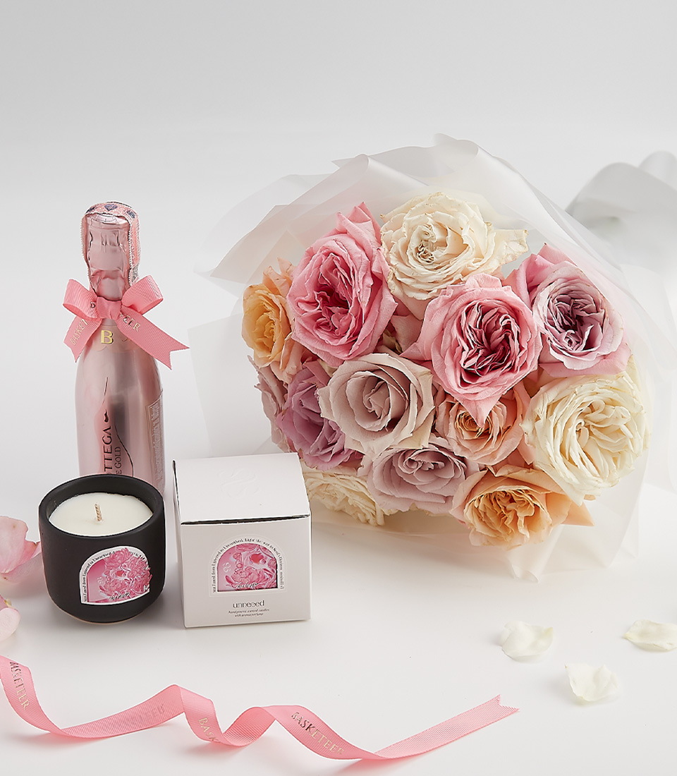 Blush rose bouquet with a scented candle and sparkling wine – a romantic gift set.