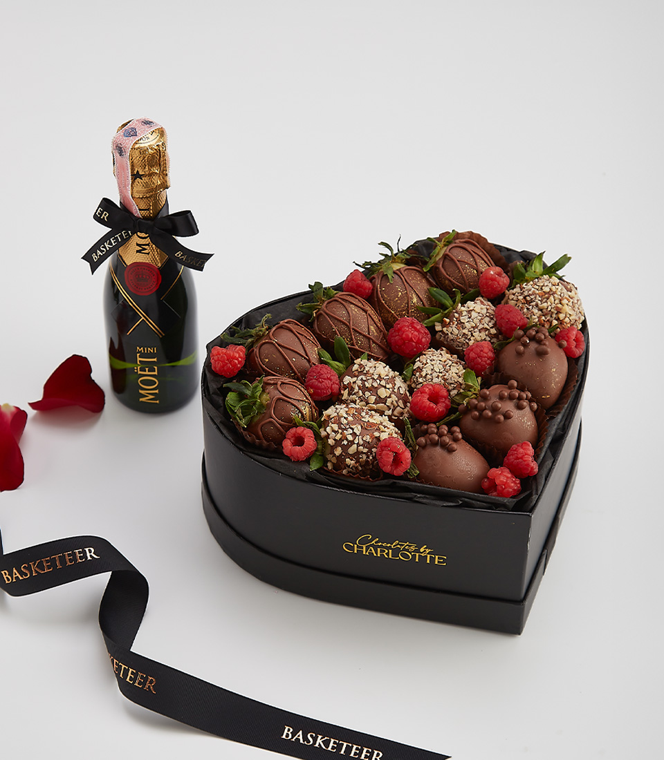 Heart-shaped gift box with dark chocolate-covered strawberries, fresh raspberries, nuts, and a bottle of Moët & Chandon champagne.