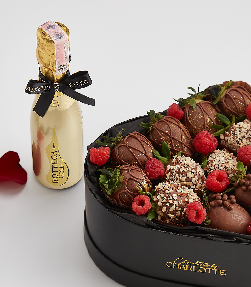 Heart-shaped gift box with dark chocolate-covered strawberries, raspberries, and a bottle of Bottega Gold prosecco.