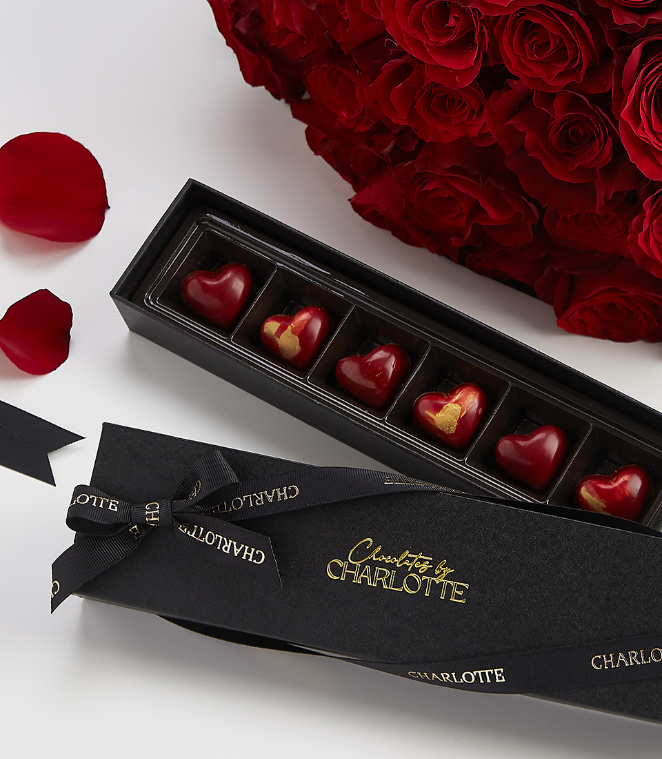 Heart-shaped chocolate box with red roses, perfect for romantic gifts.