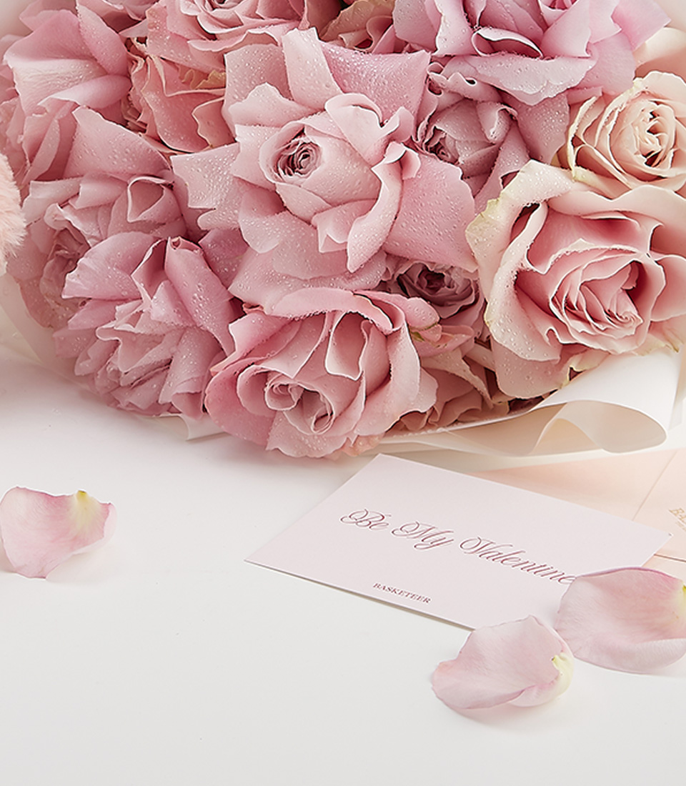 Close-up of a luxurious Valentine’s gift set including a plush pink teddy bear, elegant pink roses, and Miss Dior perfume, beautifully arranged for a heartfelt surprise.