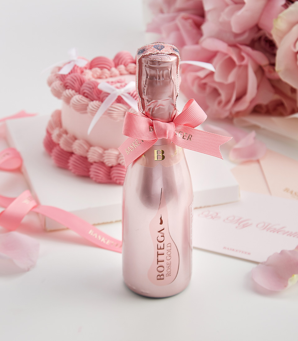 Close-up of a soft pink rose bouquet, heart-shaped cake, and Bottega Rosé mini—a luxurious Valentine’s gift set designed for romance.