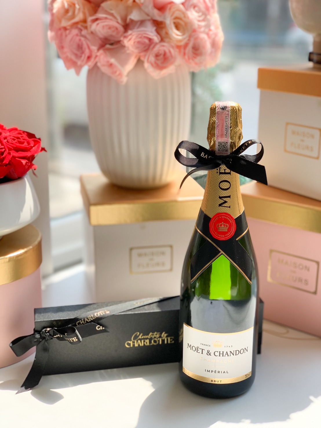 A Moët & Chandon Brut Imperial Champagne bottle elegantly wrapped with a Basketeer ribbon, paired with a luxury chocolate gift box, perfect for celebrations and premium gifting.