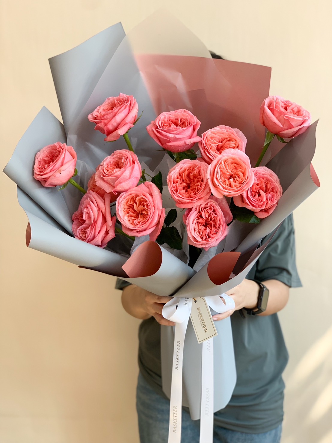 A beautifully arranged blush pink garden rose bouquet, elegantly wrapped with pastel-toned paper and a luxury ribbon.