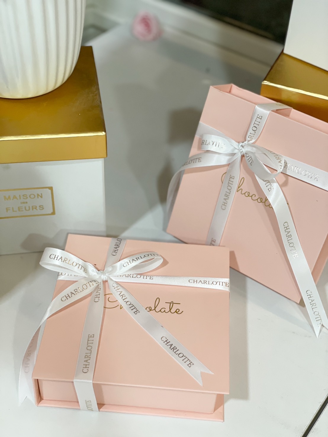A luxurious pink chocolate gift box with a satin ribbon, perfect for gifting on special occasions.