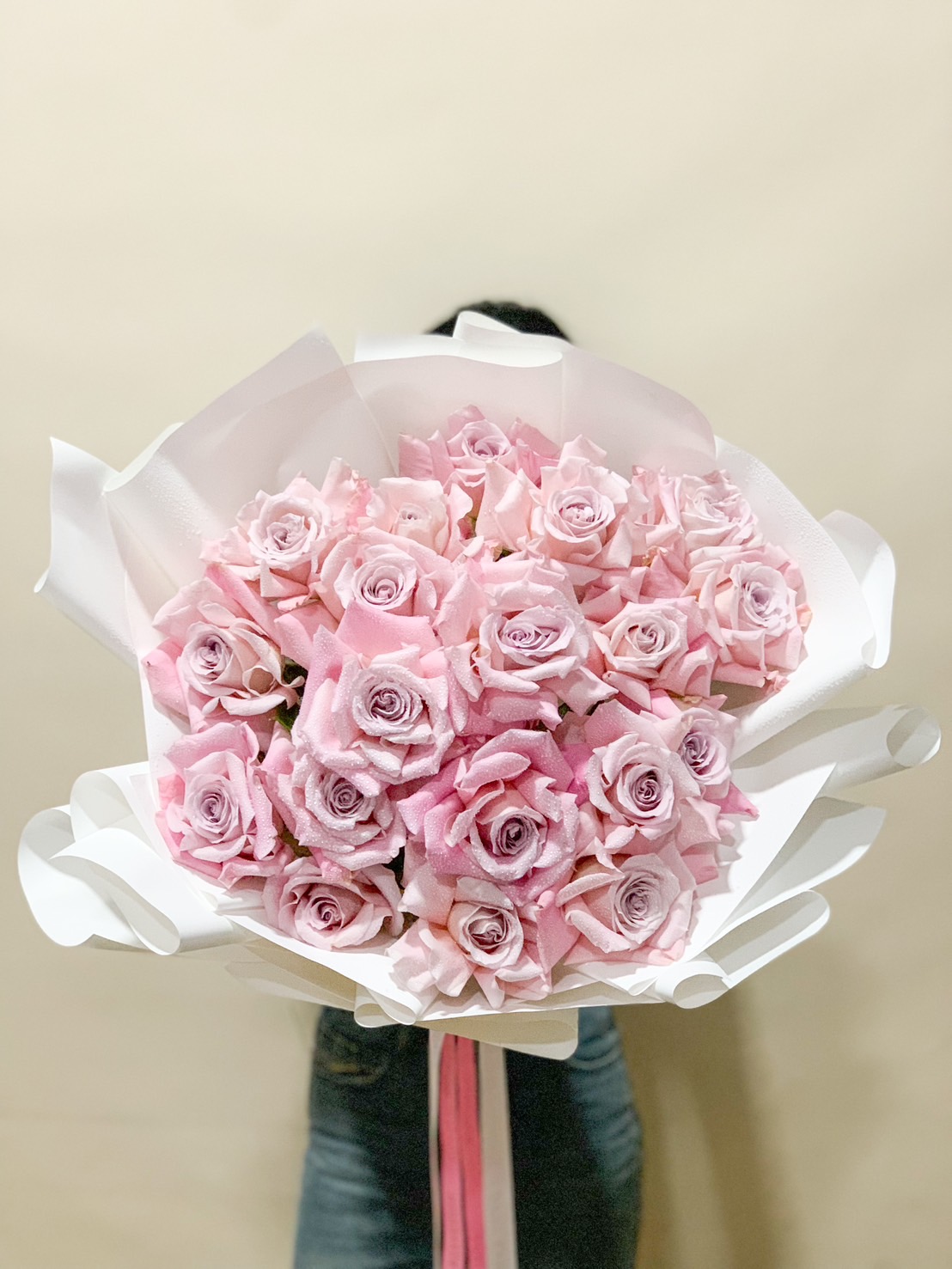 A stunning bouquet of fresh blush pink roses, artistically wrapped in white paper, perfect for romantic gifts, weddings, anniversaries, and birthdays.