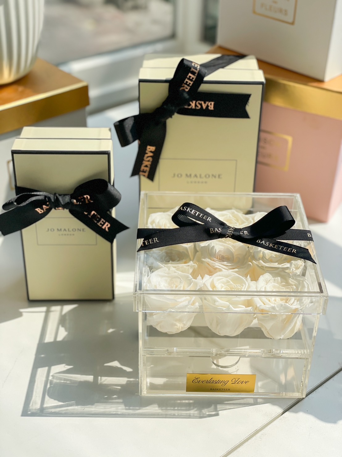 A Jo Malone London gift set beautifully presented with preserved white roses in an elegant acrylic box labeled “Everlasting Love”.