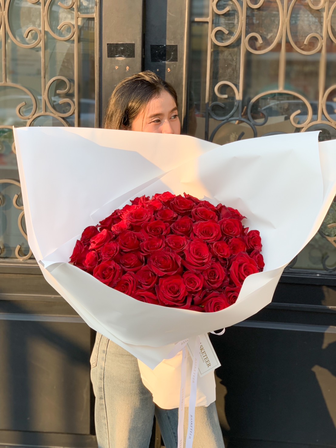 A luxurious bouquet of 99 fresh red roses, elegantly wrapped in white, perfect for romantic occasions like Valentine’s Day, anniversaries, and proposals.