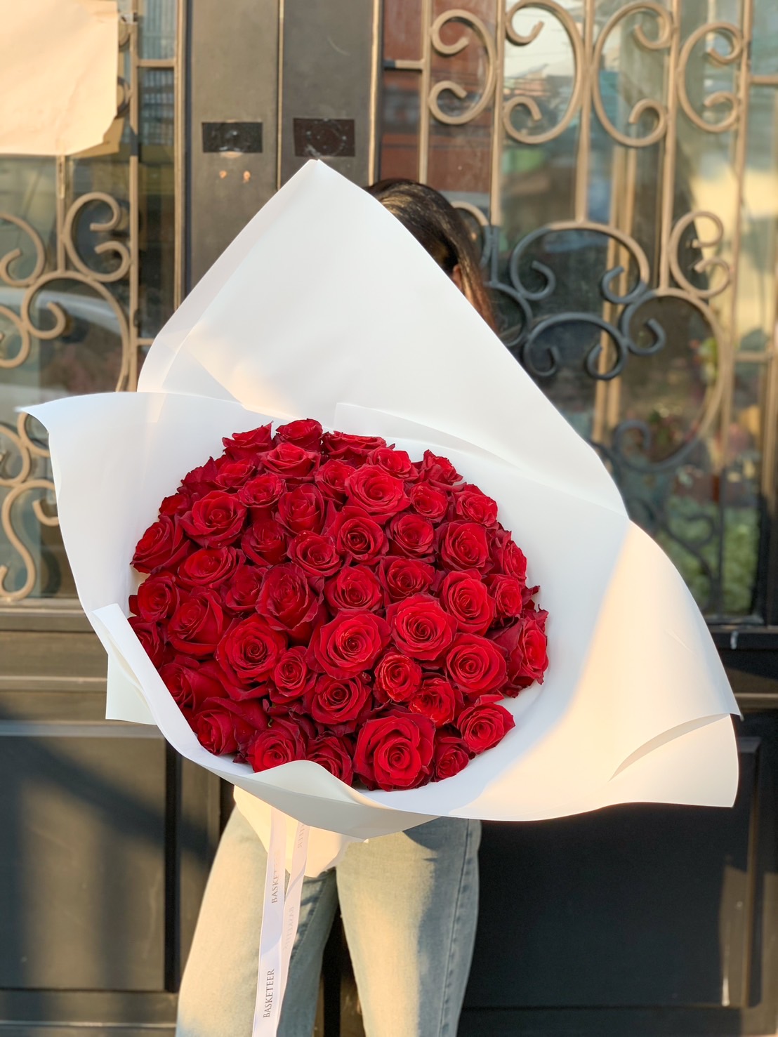 A luxurious bouquet of 99 fresh red roses, elegantly wrapped in white, perfect for romantic occasions like Valentine’s Day, anniversaries, and proposals.