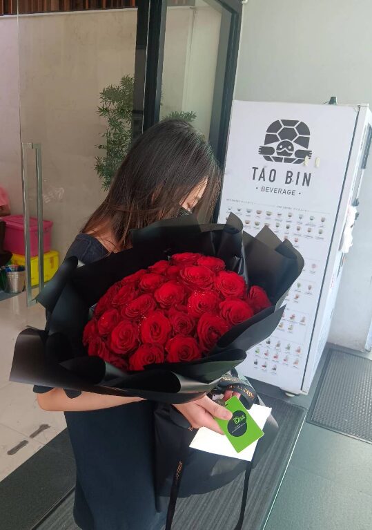 A breathtaking bouquet of premium red roses, wrapped in sophisticated black paper, creating a striking and elegant contrast. Ideal for romantic occasions and special surprises.